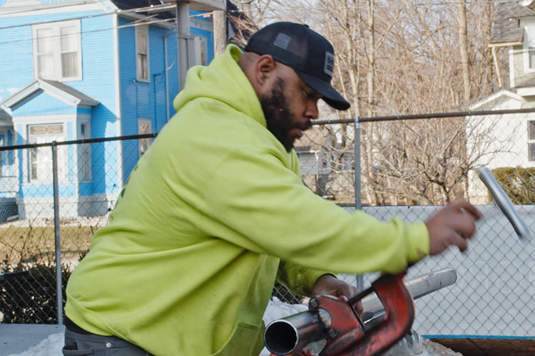 murray cutting pipe to create a fire suppression system on a construction site